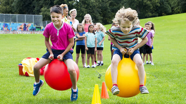Students bouncing on balls outside