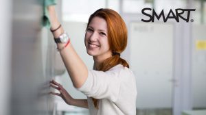 Woman cleaning and disinfecting SMART Board. 