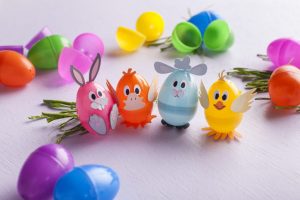 Pink, orange, light blue, and pale yellow plastic Easter eggs decorated with Cardstock animal faces